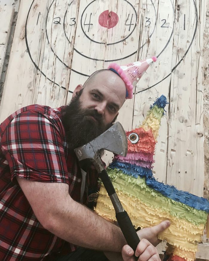 Guest holding an axe and a birthday piñata